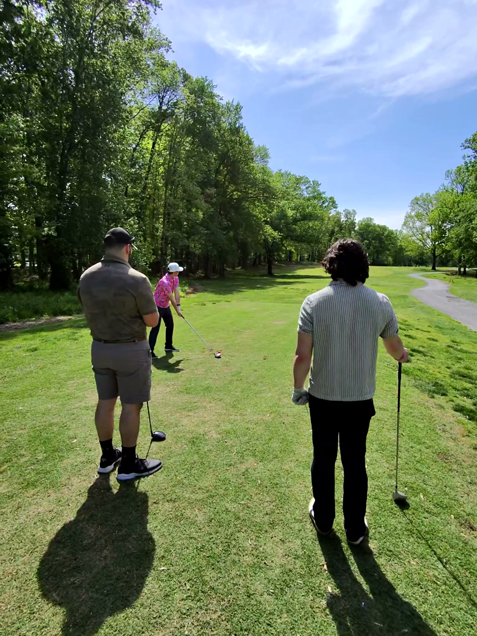 Three golfers in tracked polo shirts